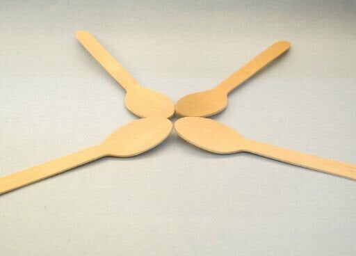This is an image of 4 wooden spoons kept against light color background.