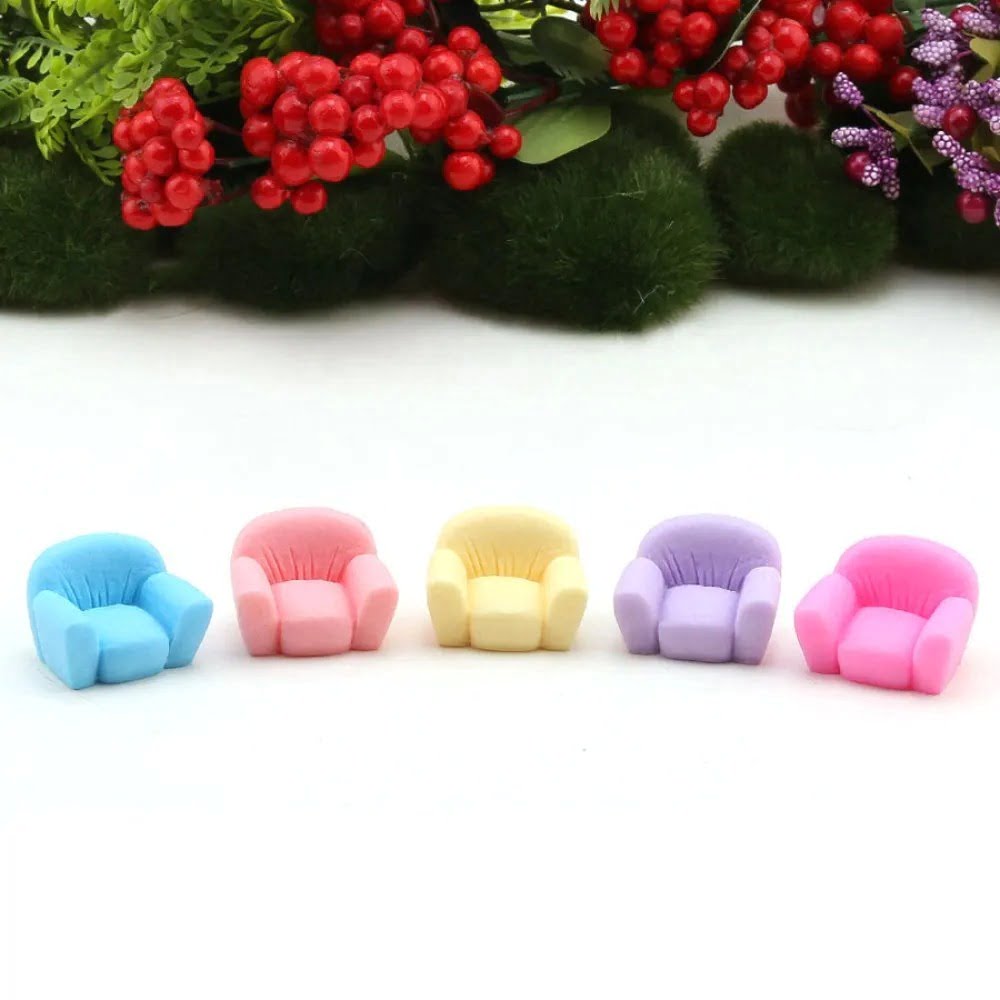 A cute multicolor Miniature Sofa/ Mini Sofa on a white floor with colorful flower and grass in the background.
