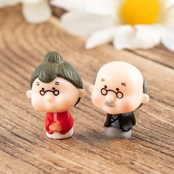 A cute Miniature Old Couple Grandparents kept on a wooden table.